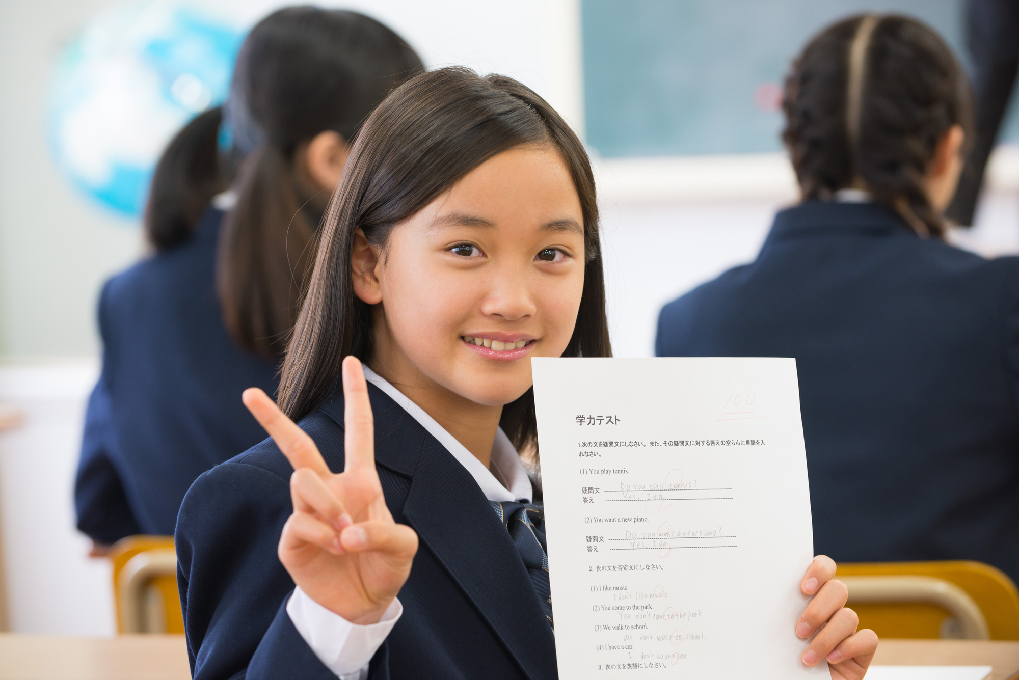 学力テストを見せてピースする女子中学生