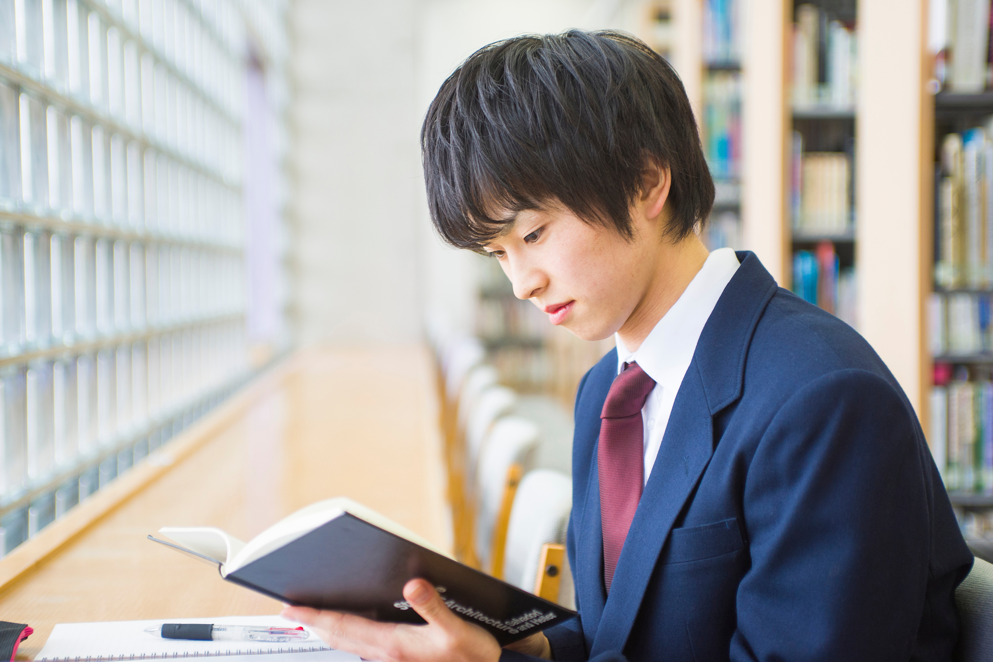 図書室で調べ物をする男子生徒