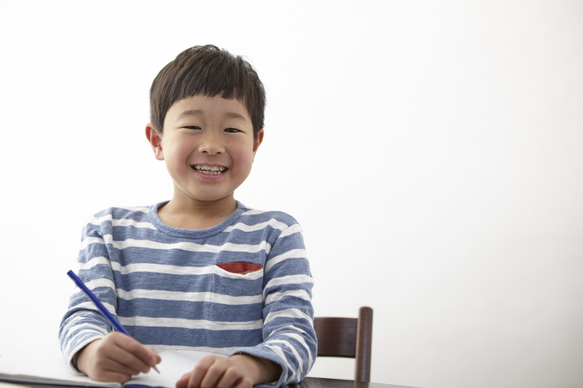 笑顔で勉強する青いボーダー服の男の子