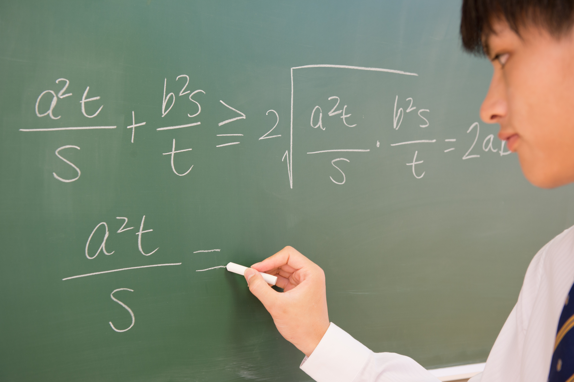 黒板で数学の問題を解く男子中学生