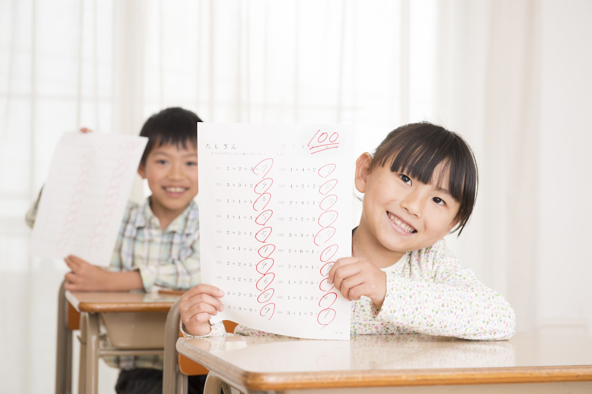 100点の答案を掲げる女の子